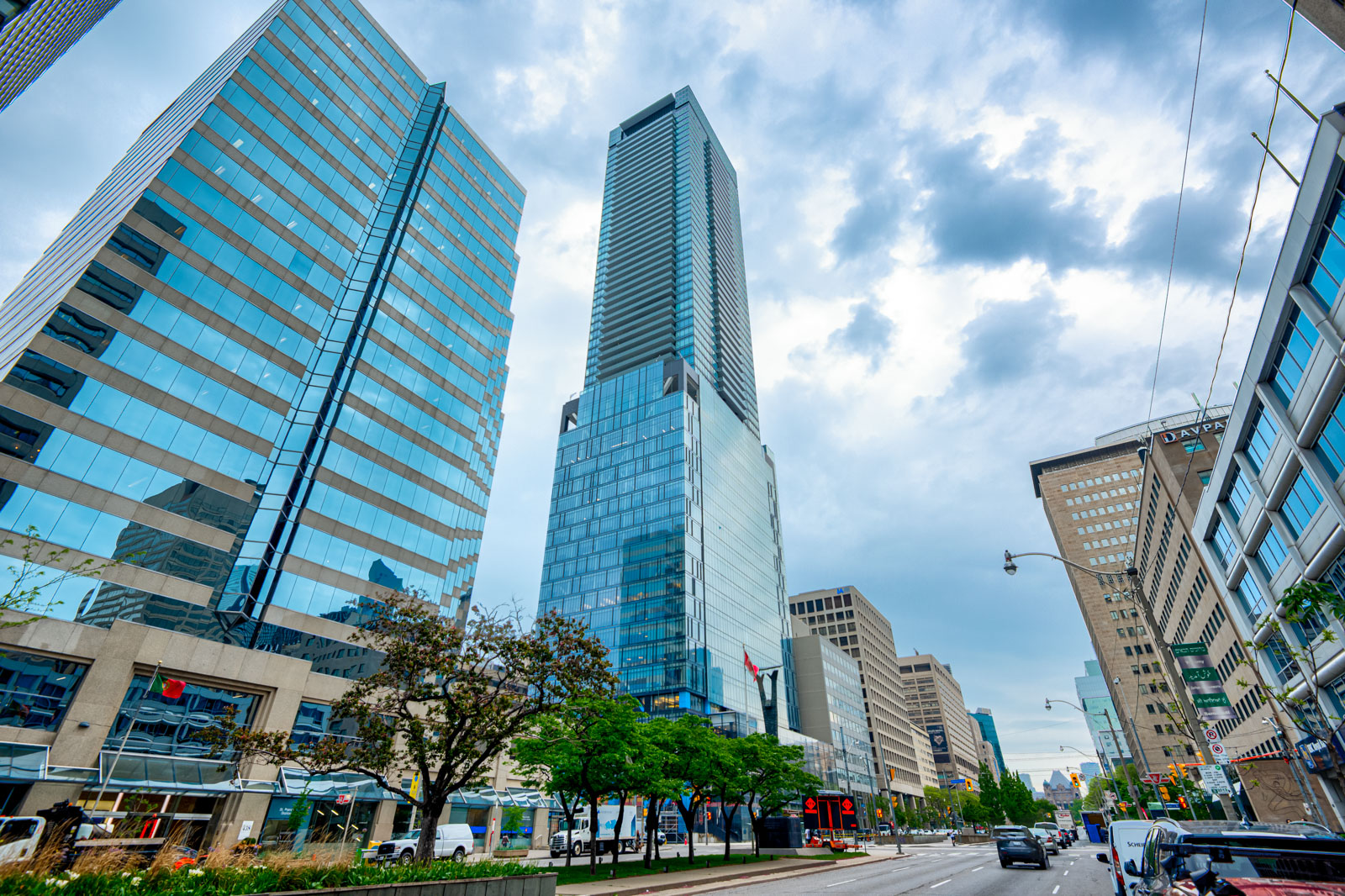 Across the street view of tall blue-glass condo in Toronto.