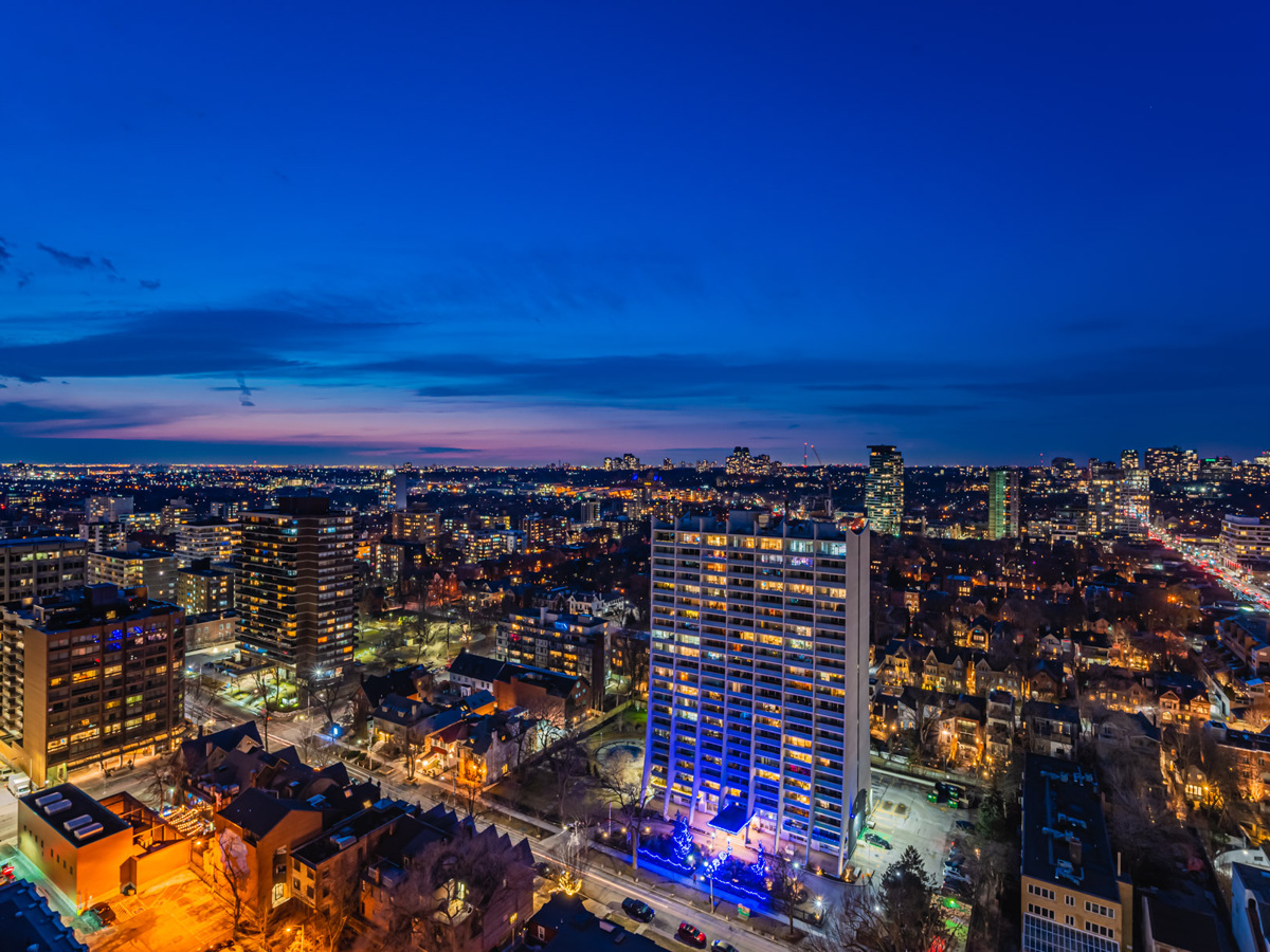 Brightly lit Toronto skyline at night from balcony.