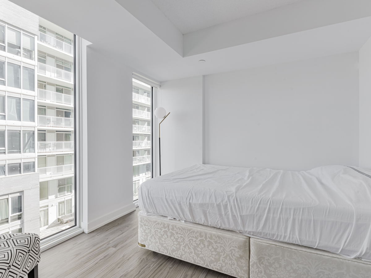 Condo bedroom with 2 floor-to-ceiling windows.