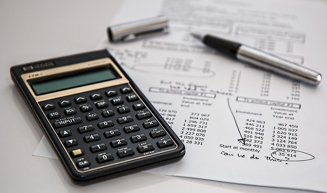 Calculator, pen and paper for FAQs about taxes, fees and rebates.