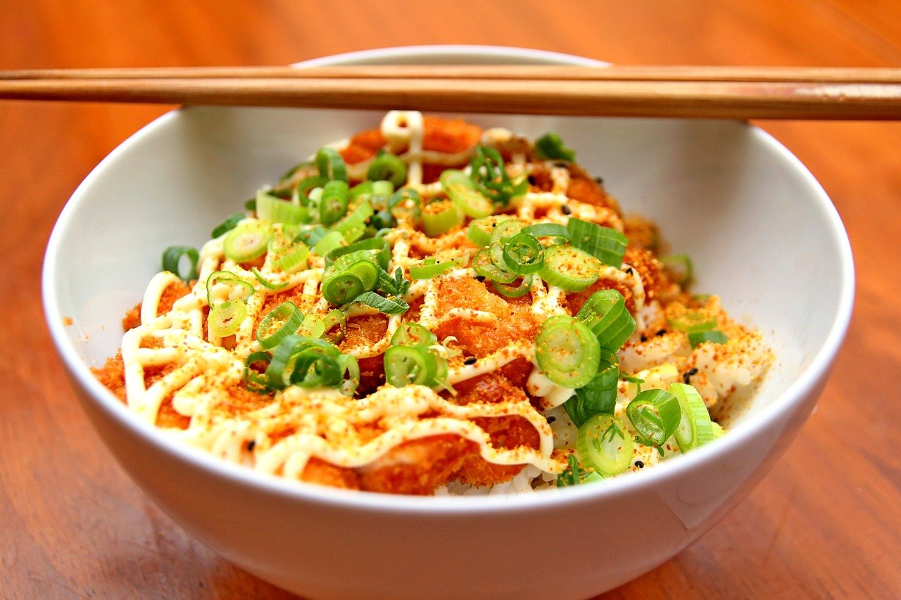 Chinese noodles with red pepper in white bowl.