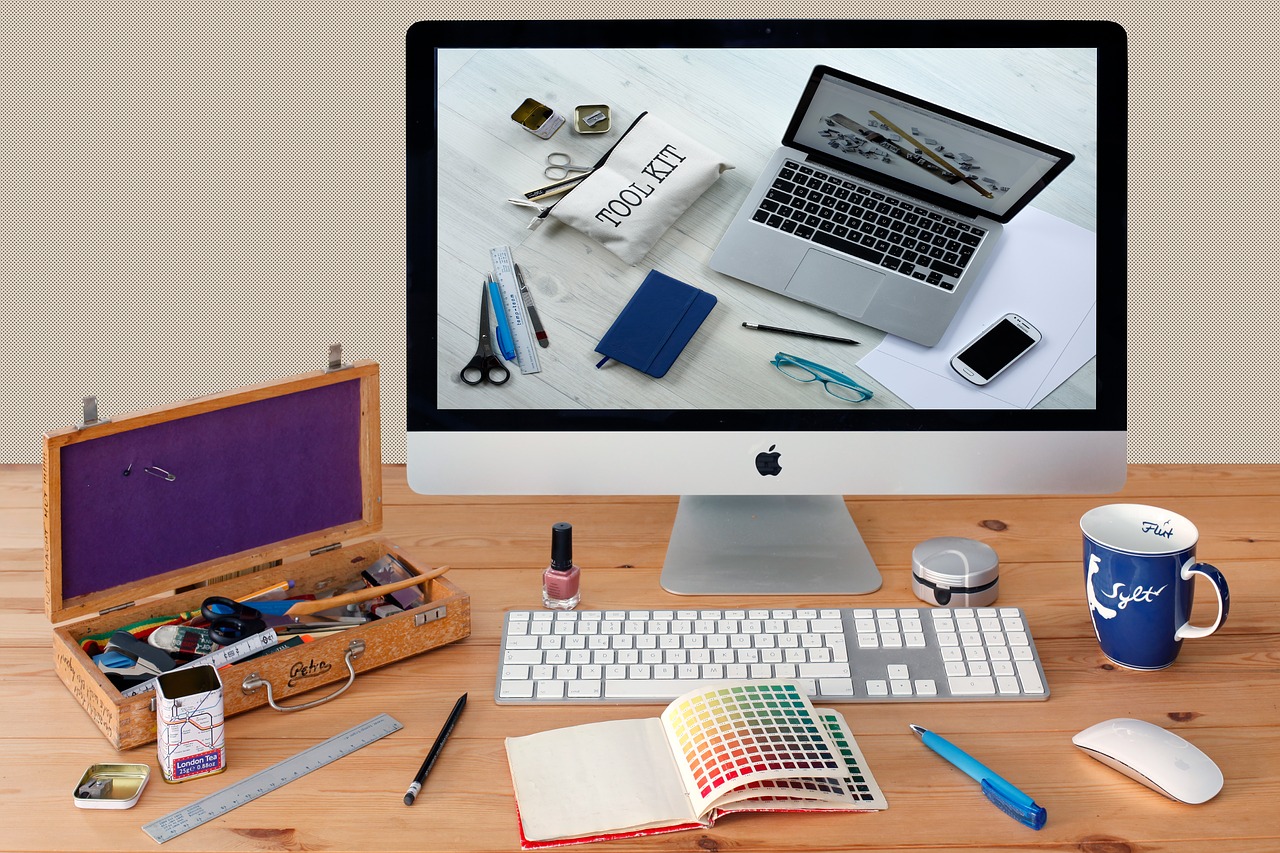 Desk with computer monitor and art supplies.