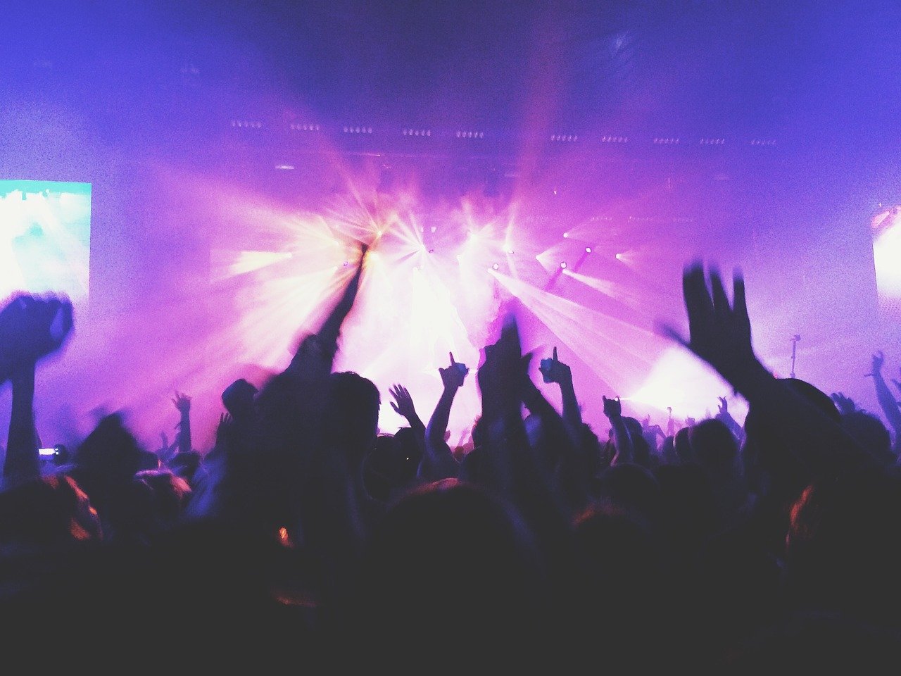 People dancing at nightclub with bright lights.