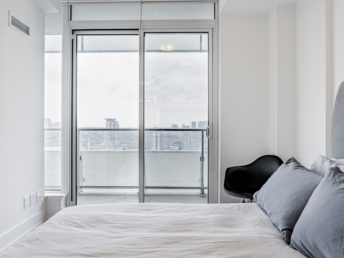 Condo bedroom with large windows.