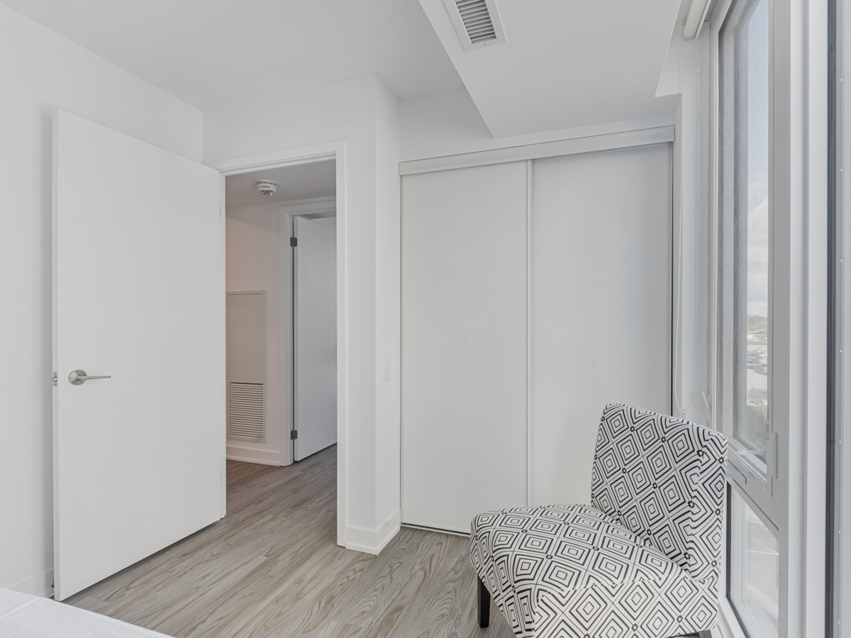 Condo bedroom with closet and chair.