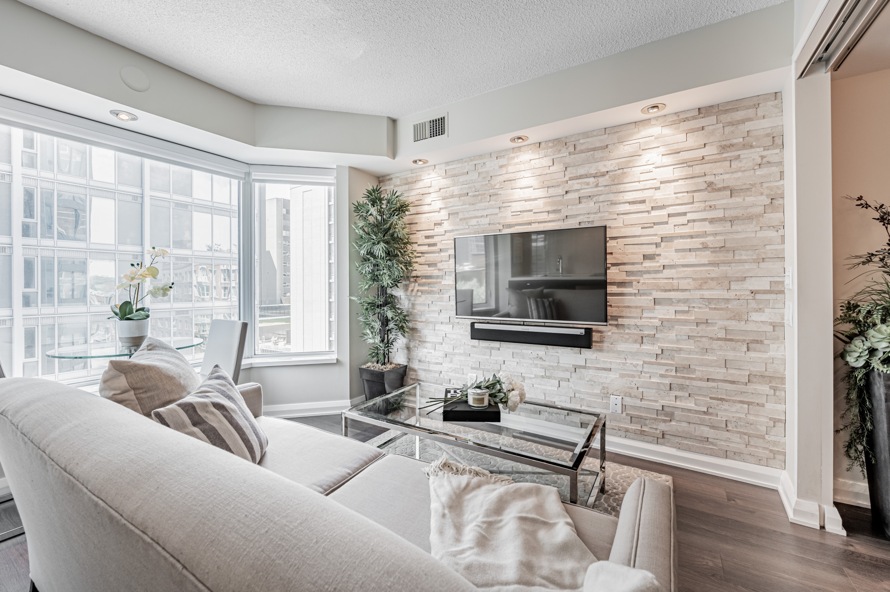 155 Yorkville Ave Unit 712 living room with lightly coloured stone accent wall.