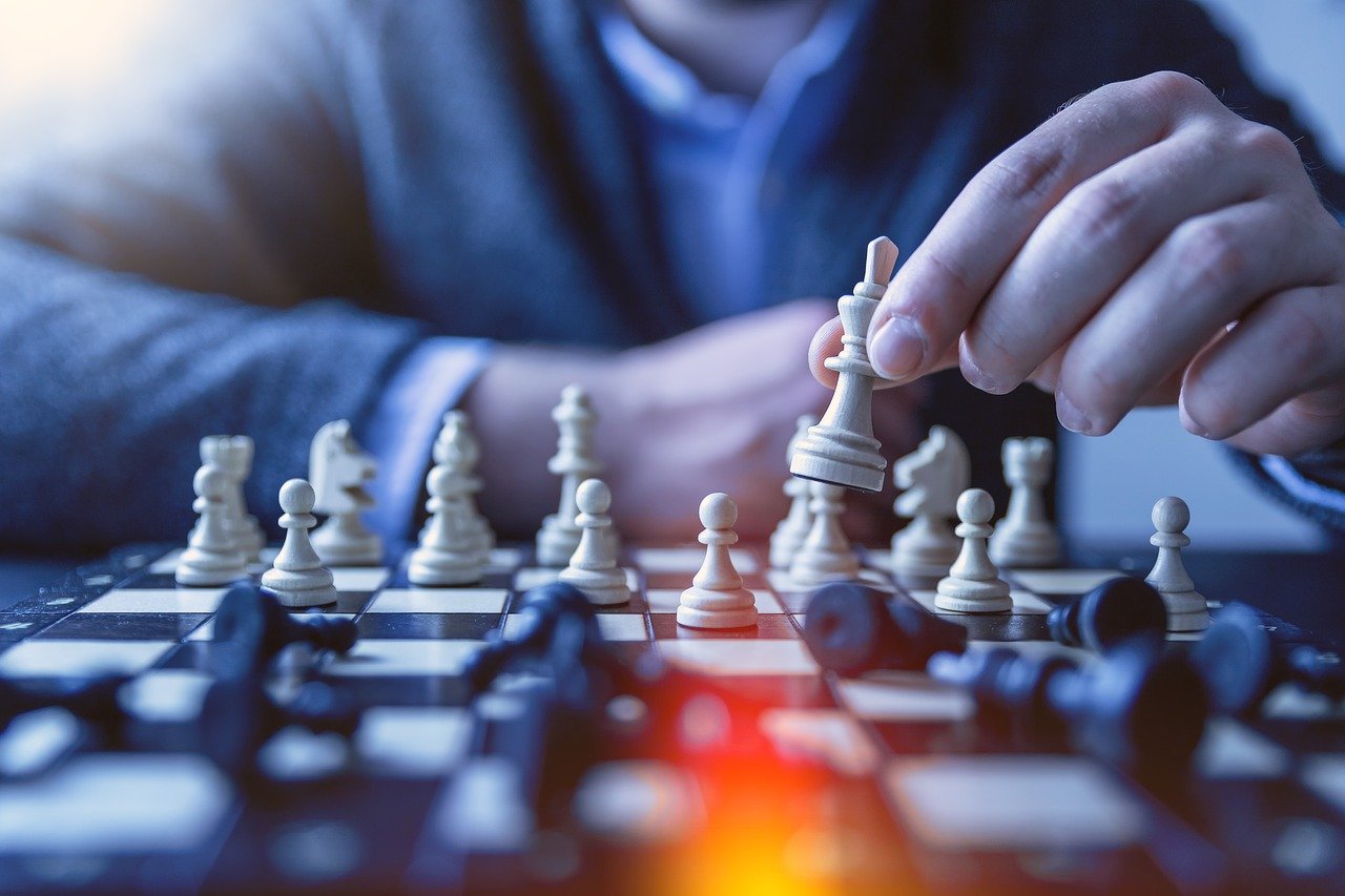 Faceless man playing chess.