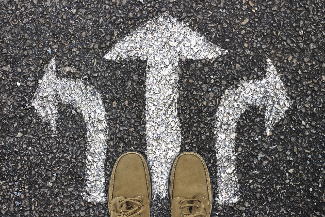 Feet standing on road with 3 arrows.