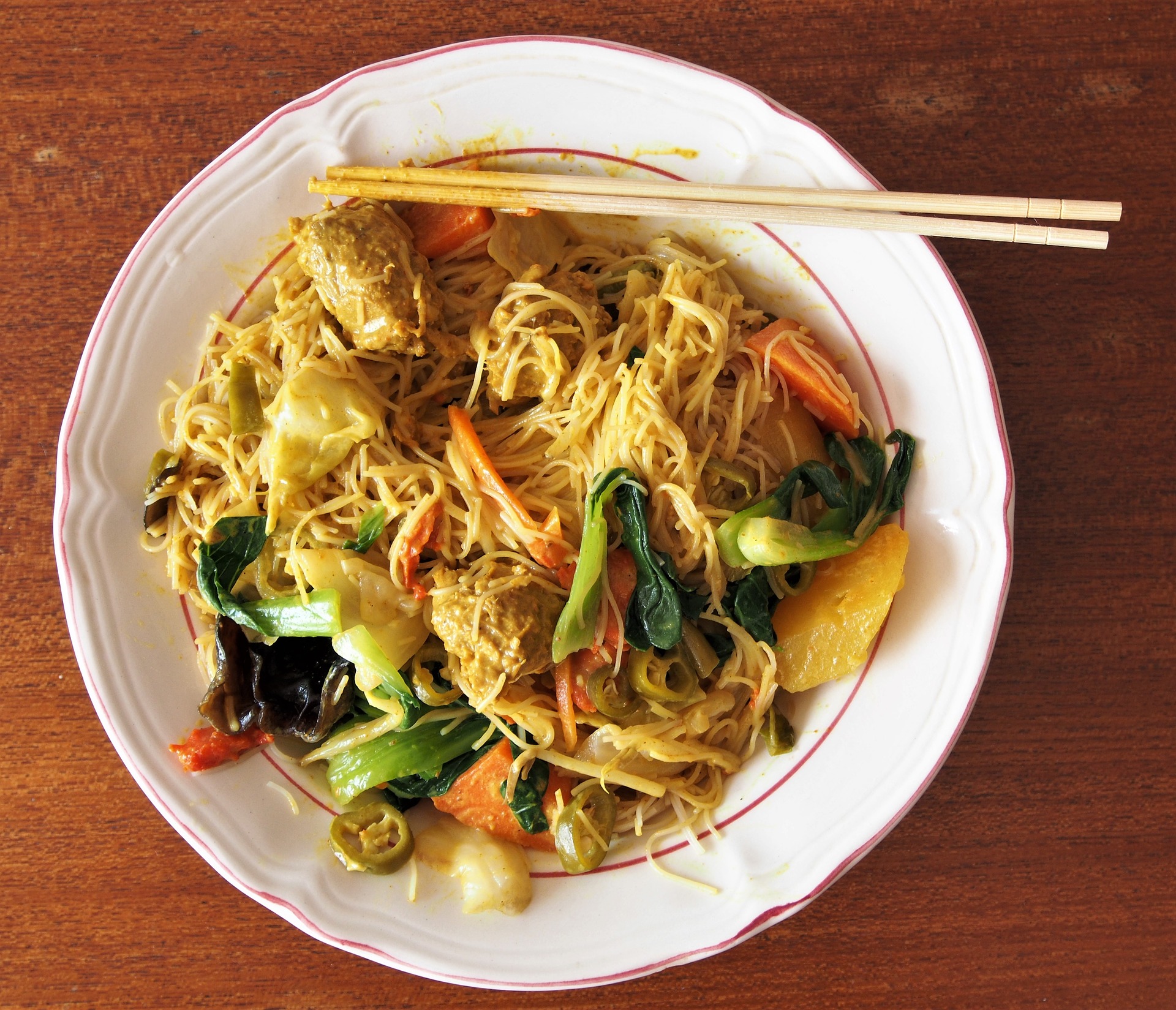 Photo of Chinese food, plate and chopsticks.