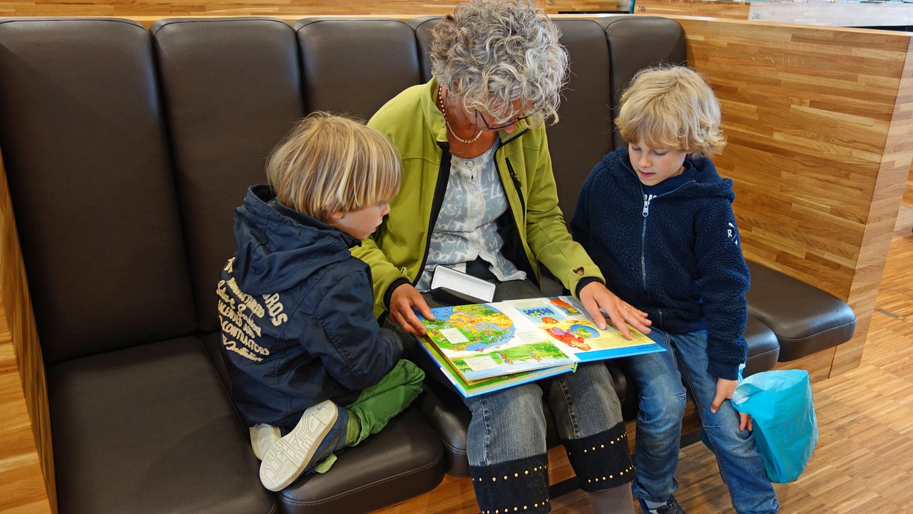 Kids and grandma reading book at library