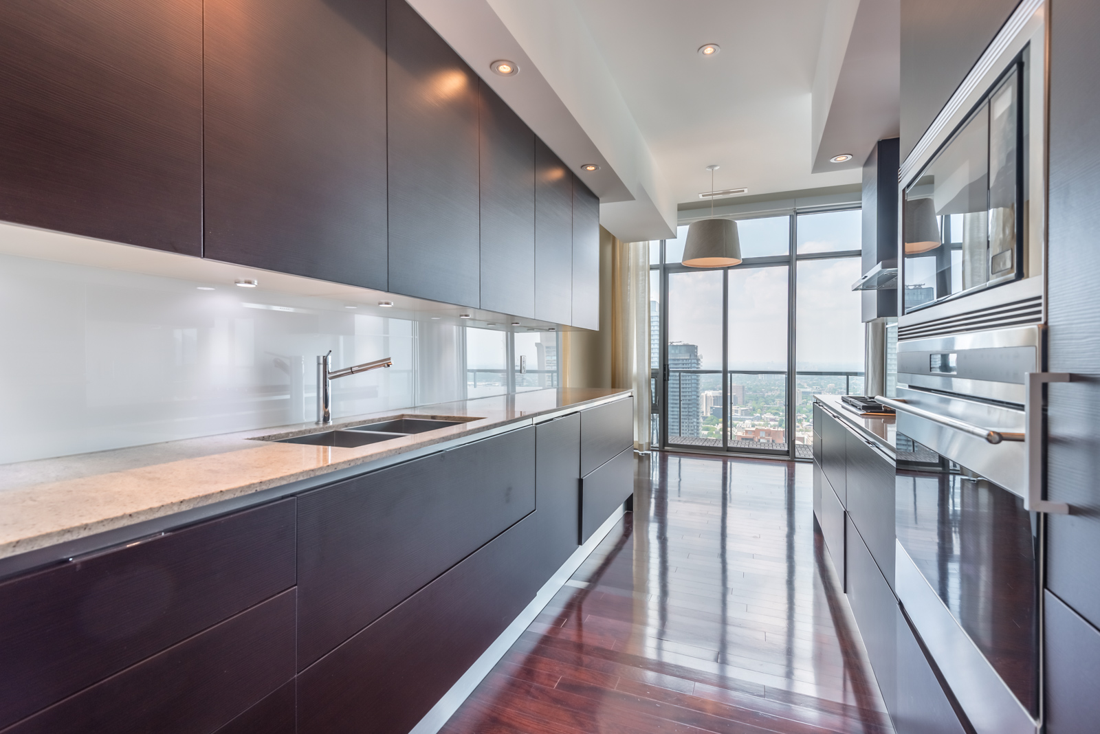 Galley kitchen with dark cabinets on either side of penthouse suite at 33 Charles St E Casa Condos.