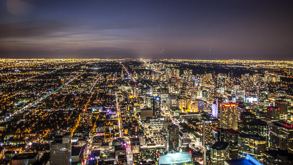 Ariel view of brightly lit Toronto skyline at night.