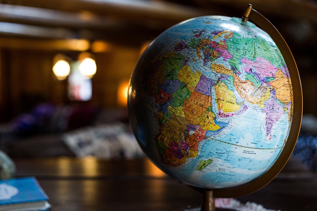 Globe of Earth in foreground with lights and bed in background.