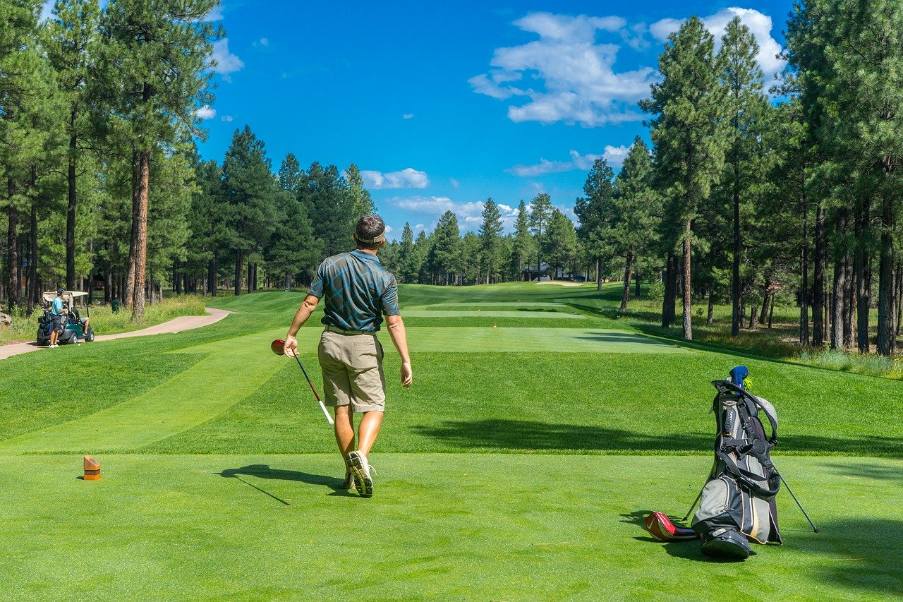 Man on golf course with back to camera.