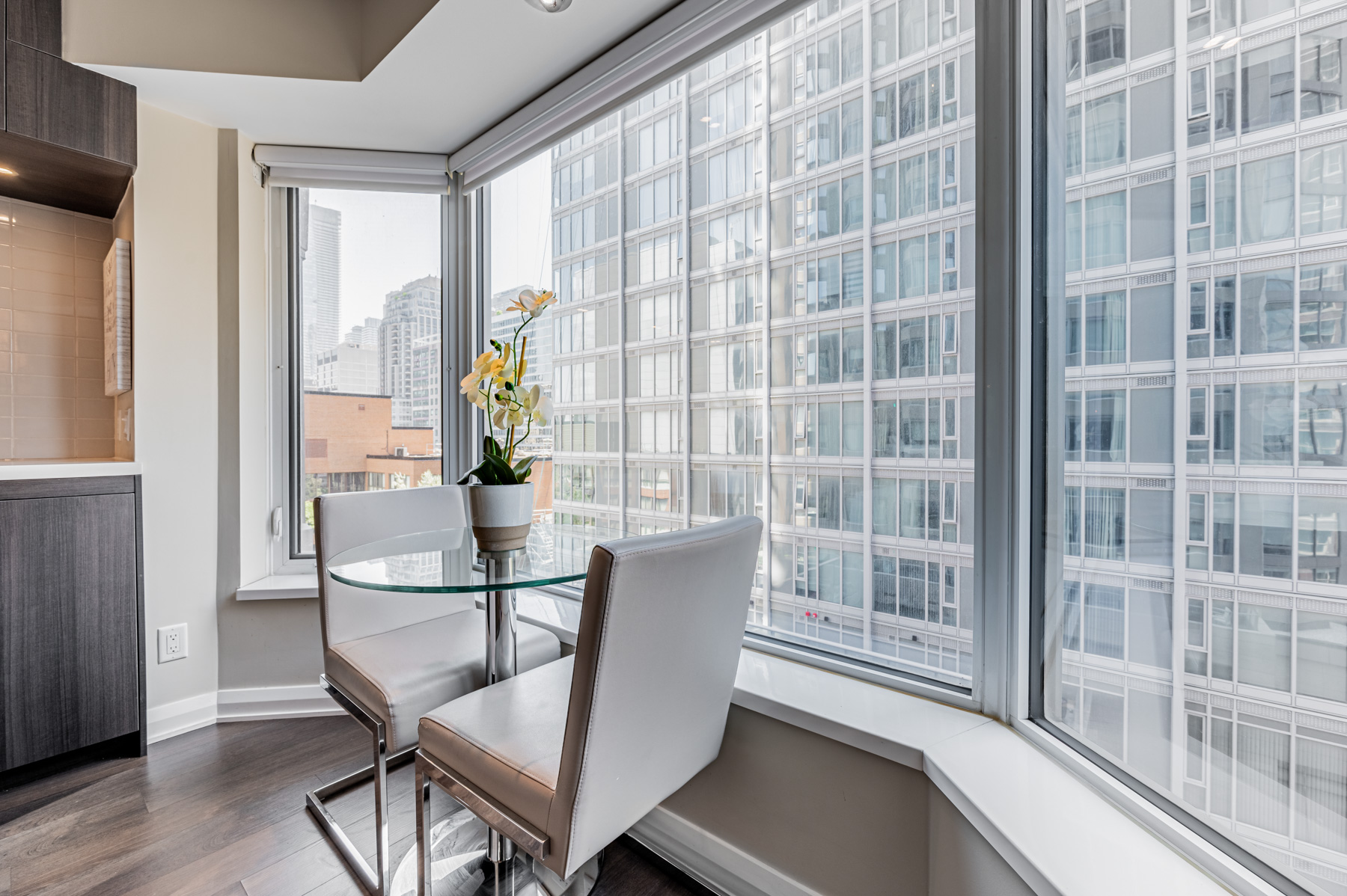 Condo dining room next to windows.