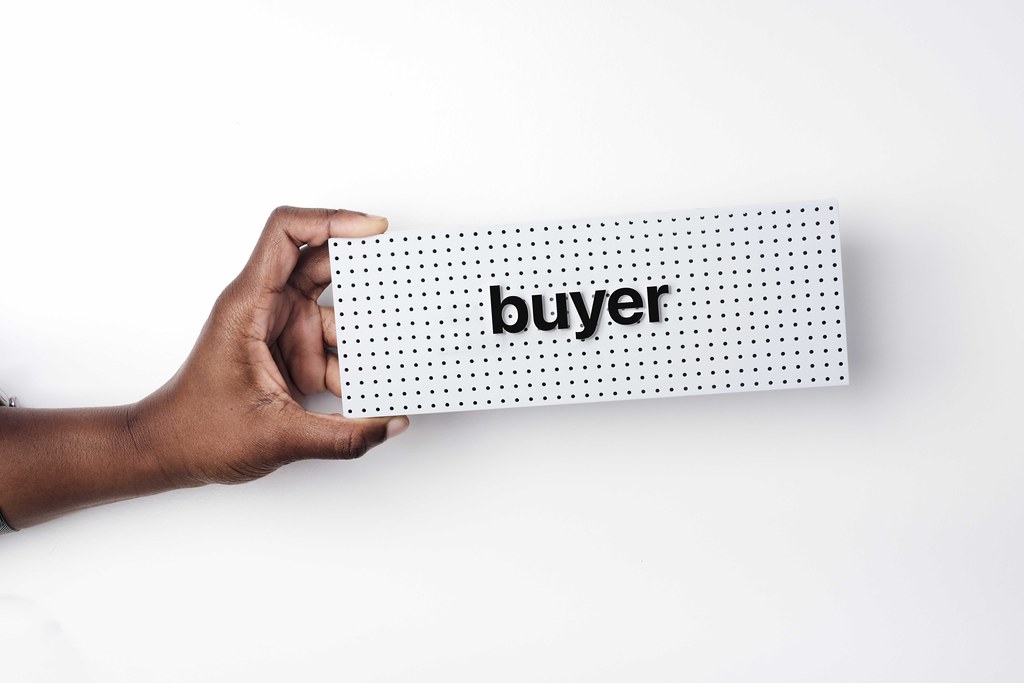 Hand hold sign saying "buyer" showing June 2022 buyer's market.