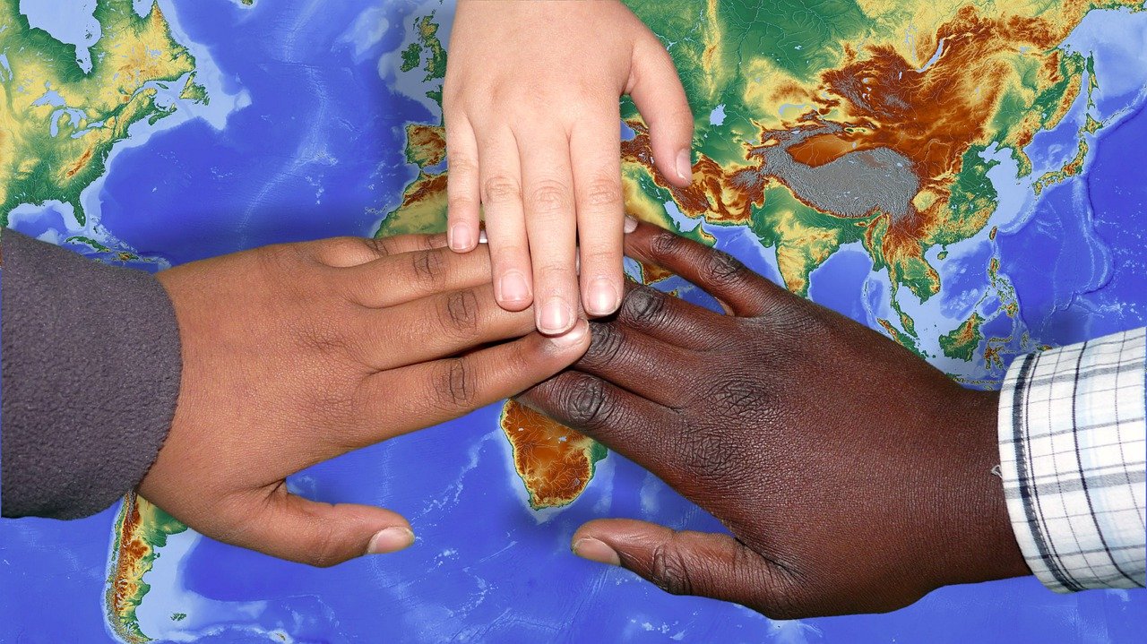 Close up of hands over map of earth showing immigration and importance of vaccines.