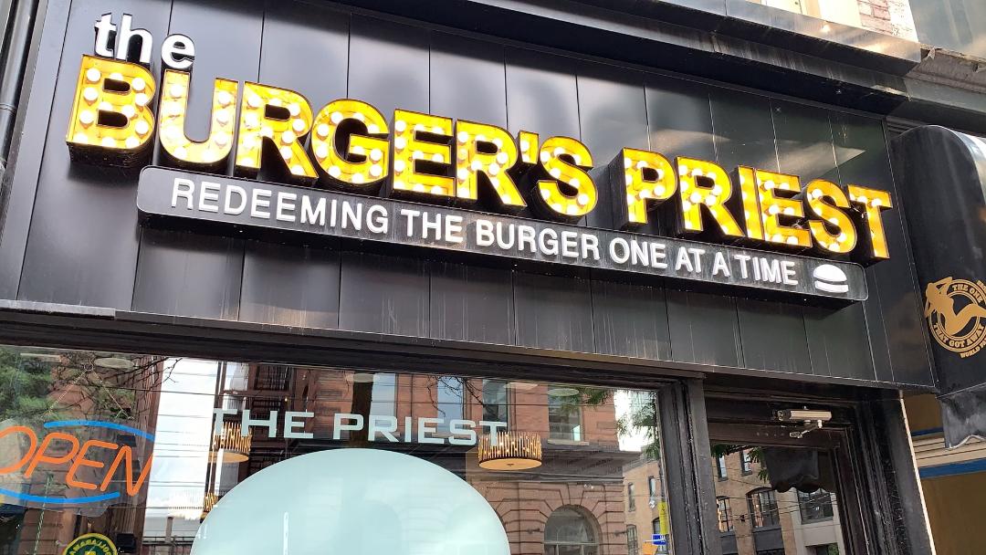 The Burger's Priest restaurant yellow sign on King St West.