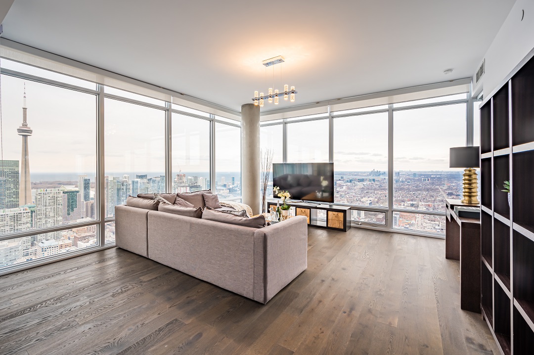 Condo living and dining room with hardwood floors, stylish lighting and floor-to-ceiling windows.