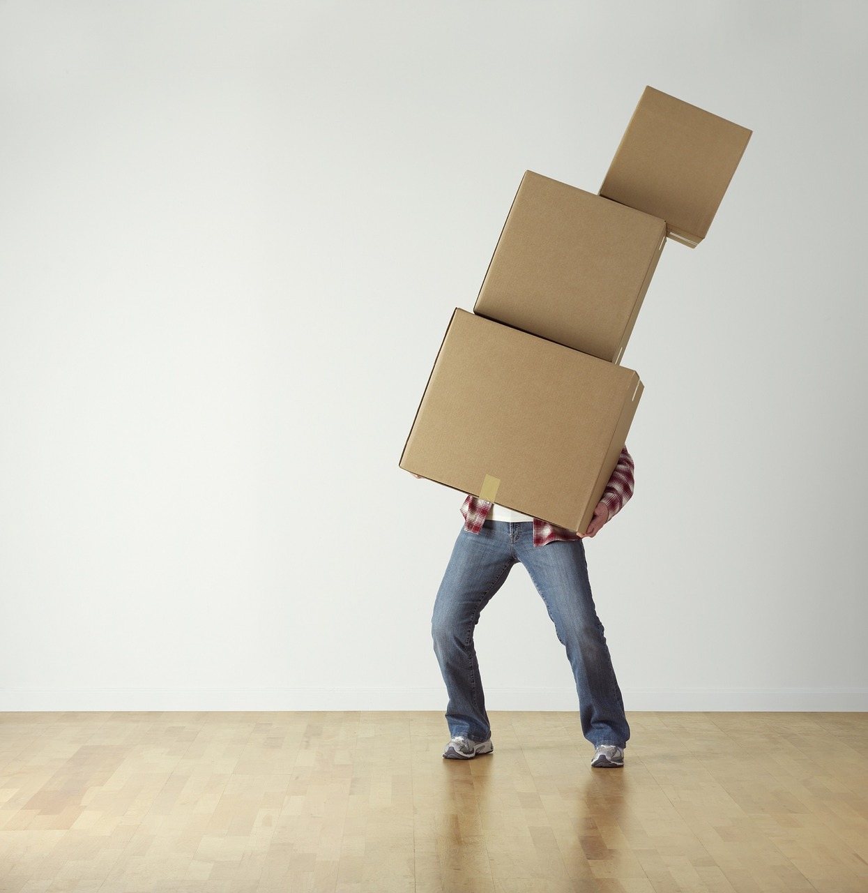 Man balancing 3 brown boxes