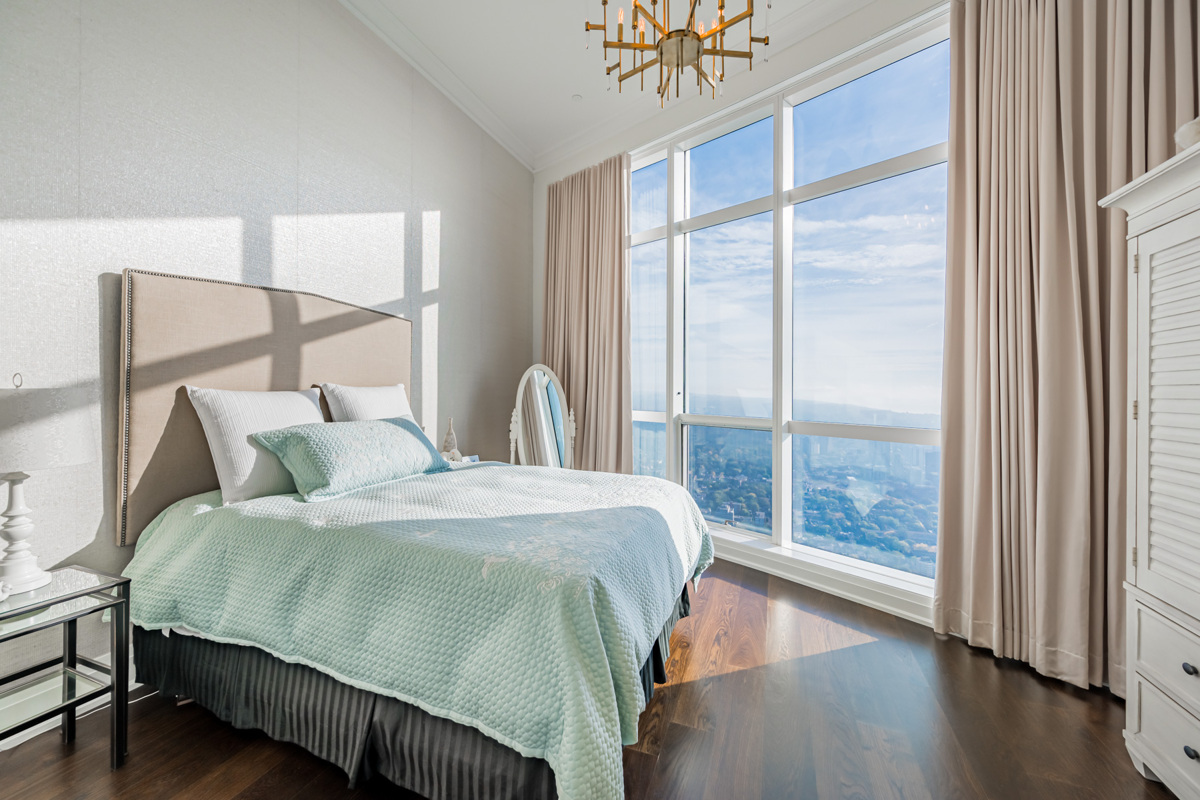 Bedroom with large windows showing Toronto.