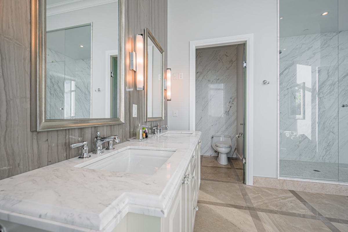 Condo bath with his and her sinks, two mirrors and storage cabinets.