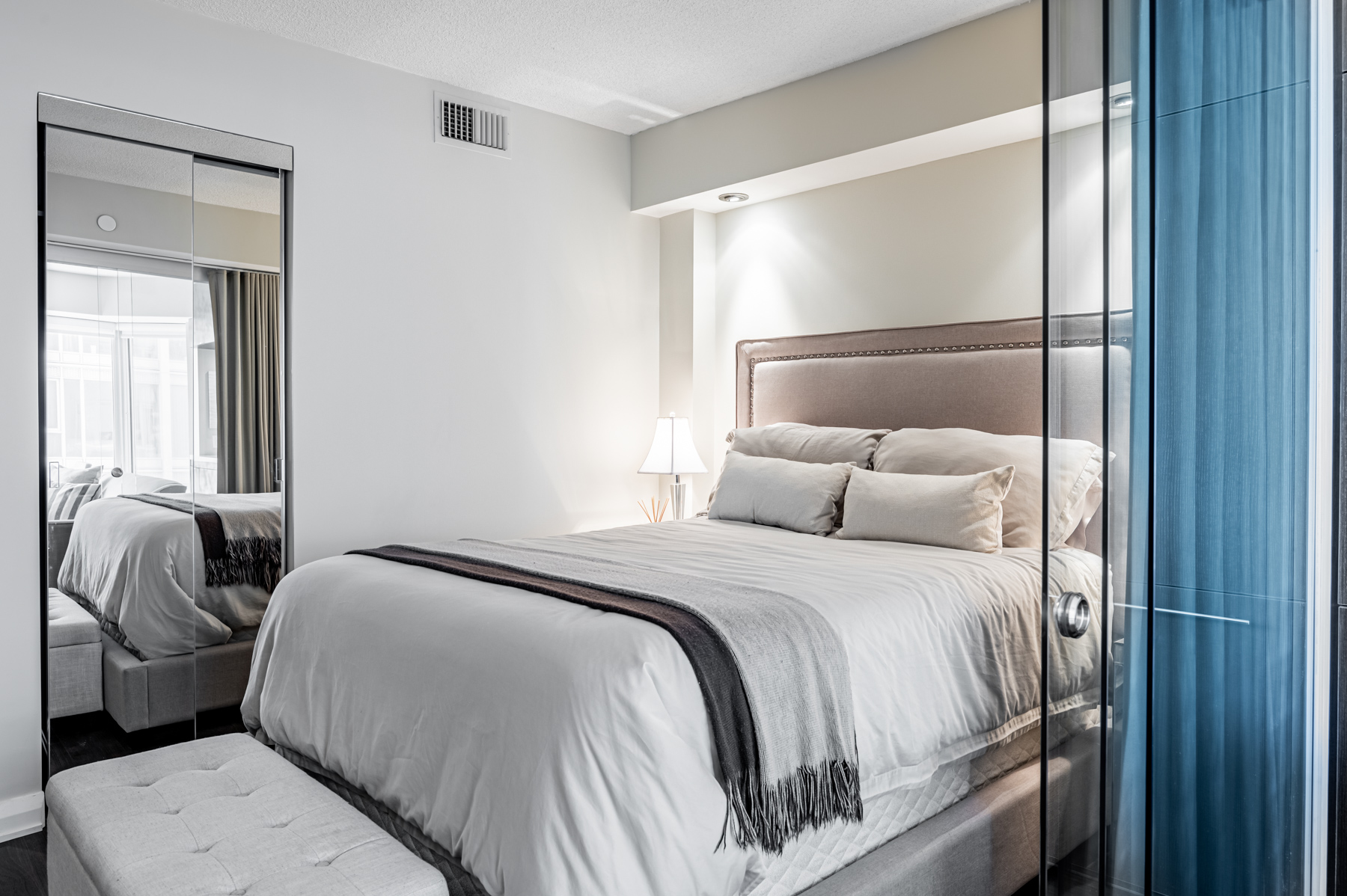 Bedroom with mirror door closet.