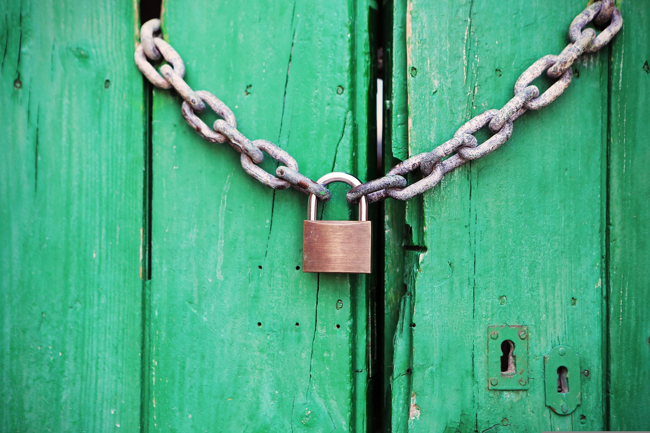 Padlock on a green door showing access to credit report is restricted.
