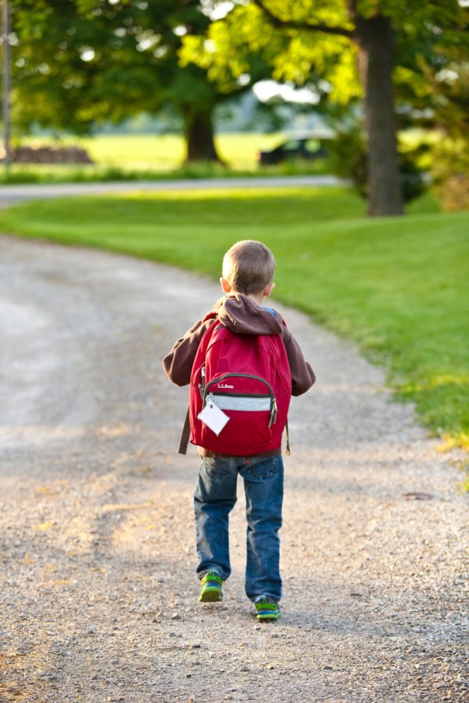 Kid with backpack walking to school