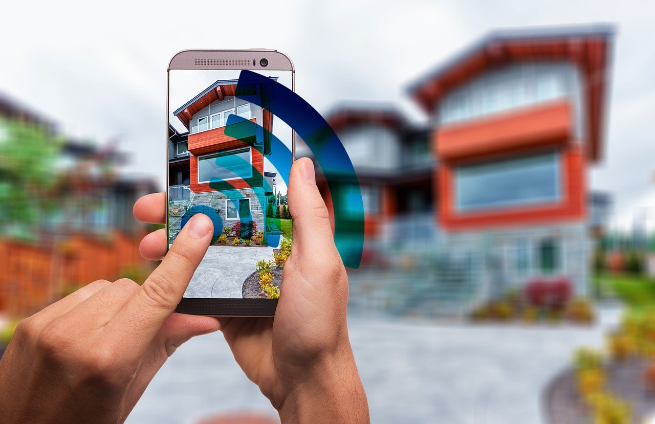 Man holding cellphone with Wi-Fi signal; red house in background.