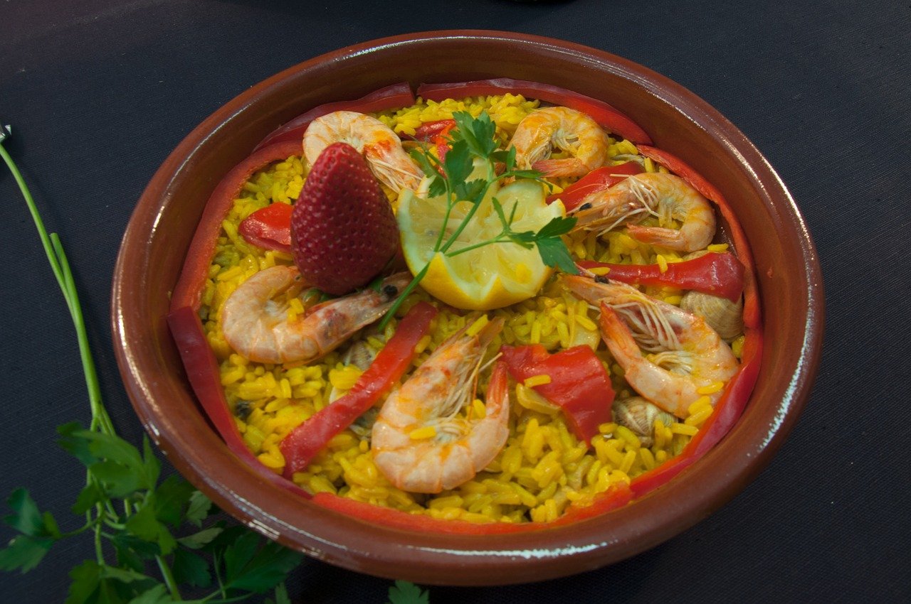 Paella in brown bowl with rice.