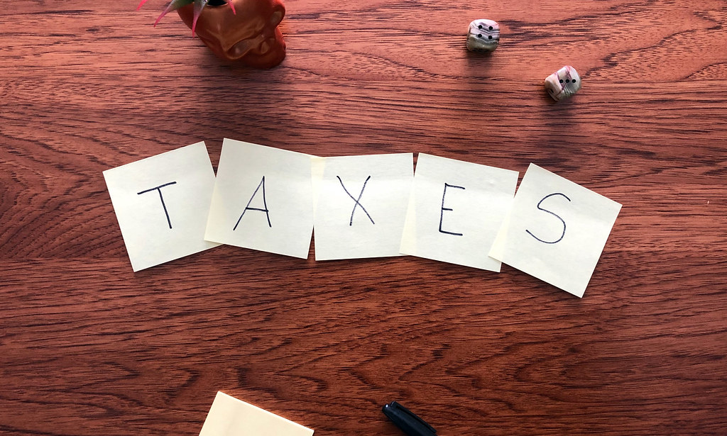 Word "TAXES" spelled out on note paper.
