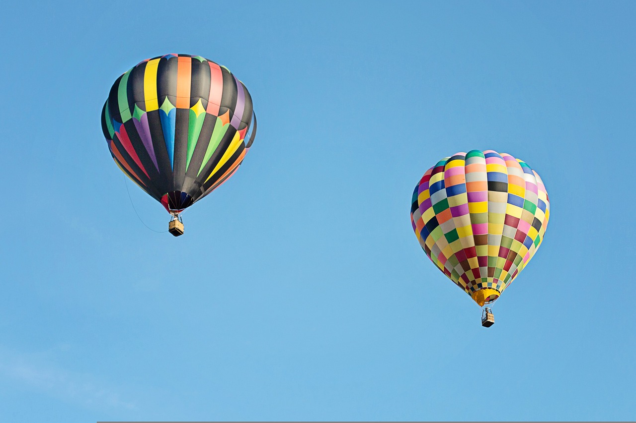 Two brightly patterned hot air balloons showing inflation.