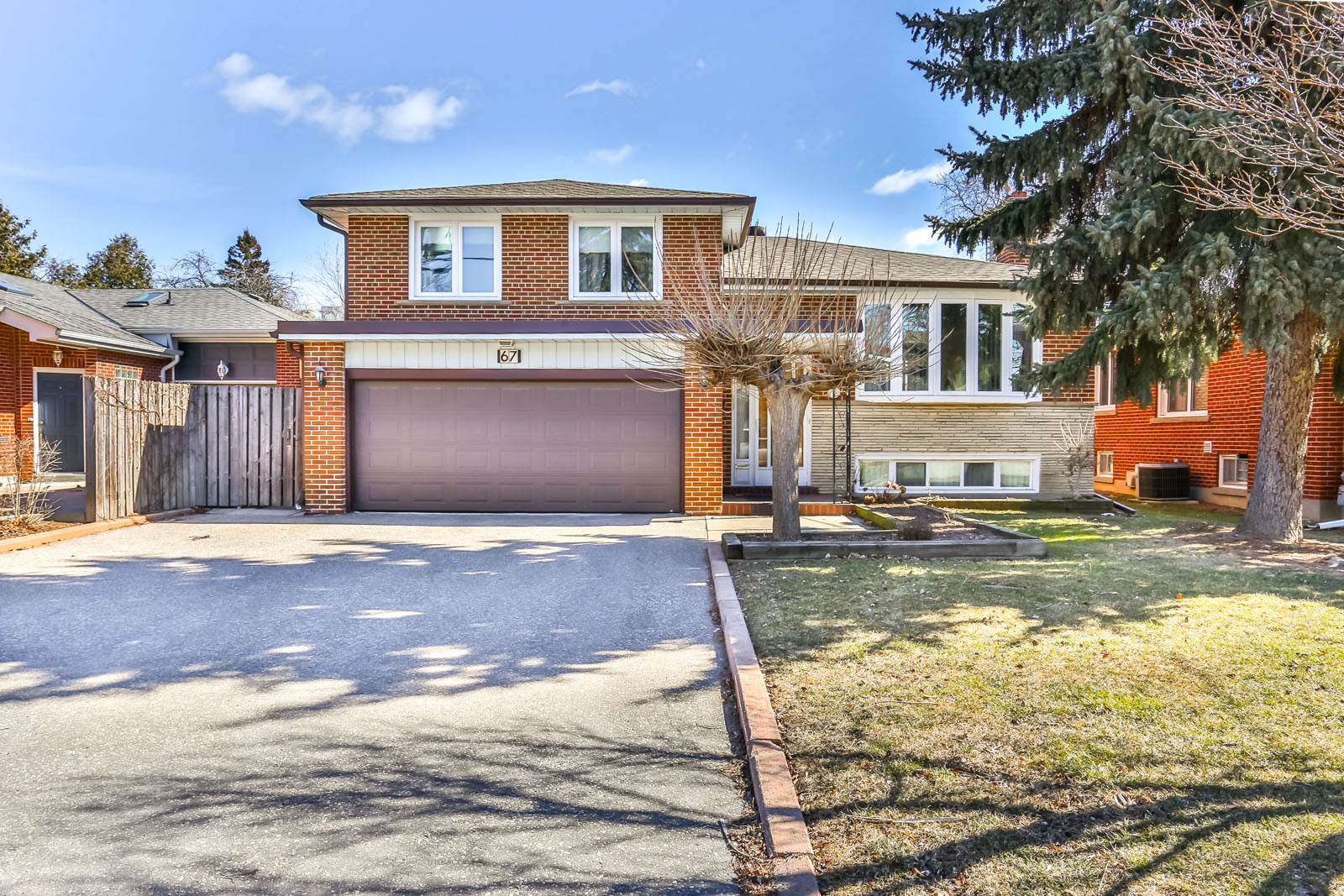 Photo of driveway and house. The driveway is so wide that it can fit 4 cars.