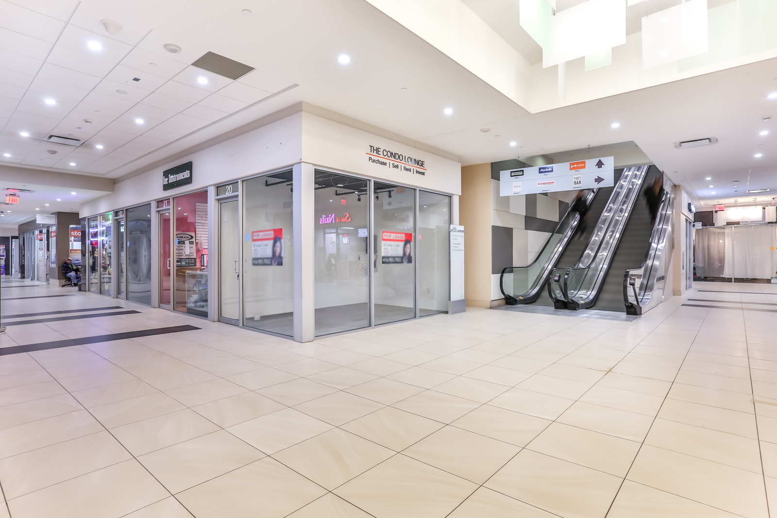 Photo of Aura's shops. We can see so many pot-lights and an almost pure gray colour scheme.