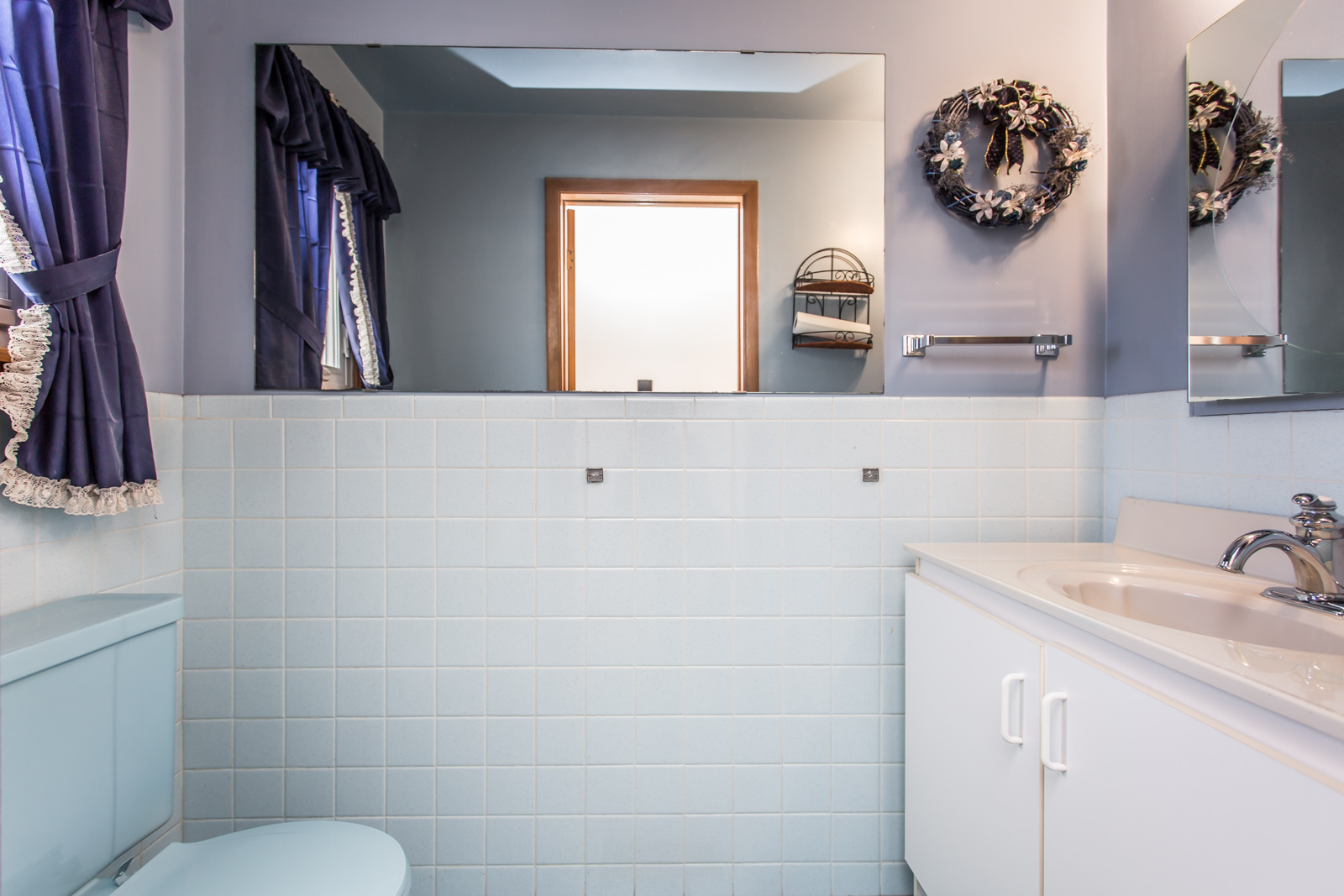 Powder room is rather rich in white and purple. So much of it has tiles.