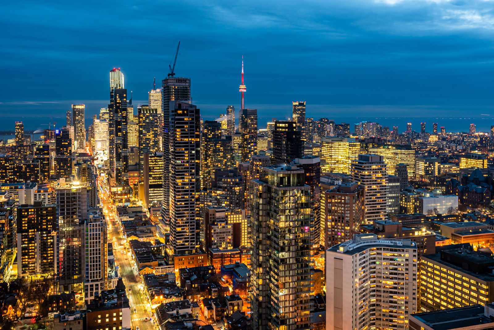 Aerial view of Toronto skyline at night with bright city lights and streets.