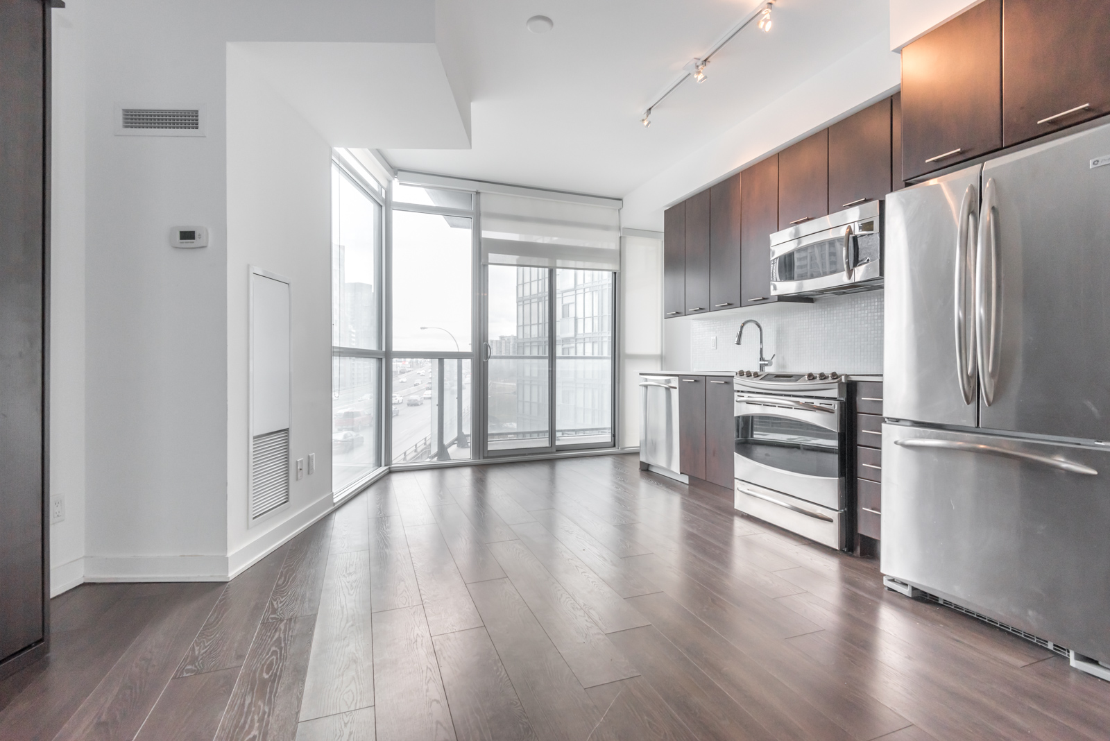 Photo shows 169 Fort York and its kitchen, floors, and balcony. So much of it is lit up.