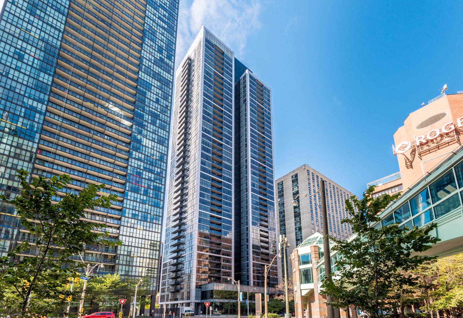 Daytime across-the-street view of The Couture Condos, a 42-floor building with highly-reflective glass.