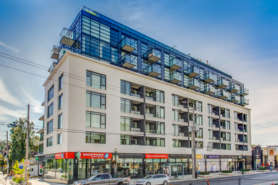 Exterior of The Hill Condos with shops at ground level.