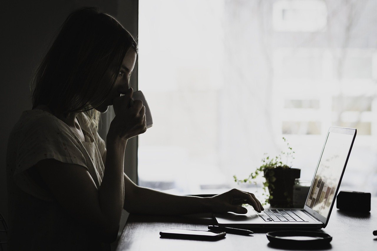 Pre-Buying Tip #1 shows woman drinking coffee while using laptop to do research.