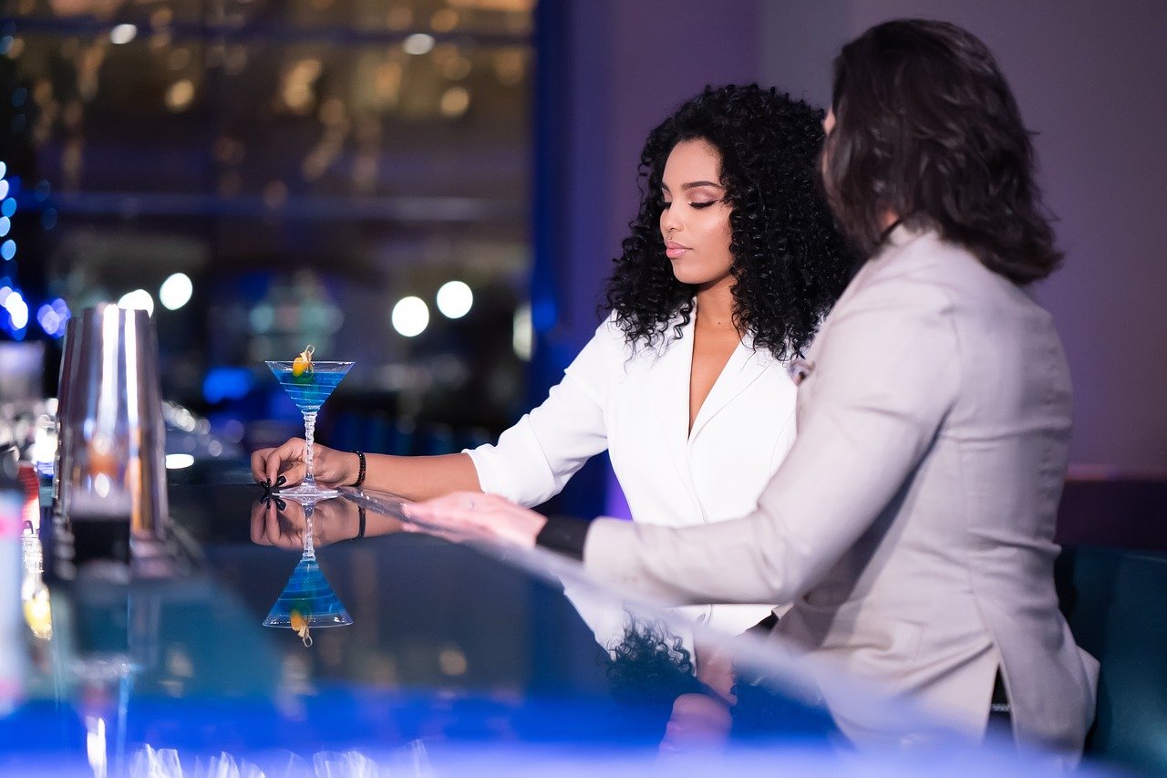 Women in suits at bar counter.