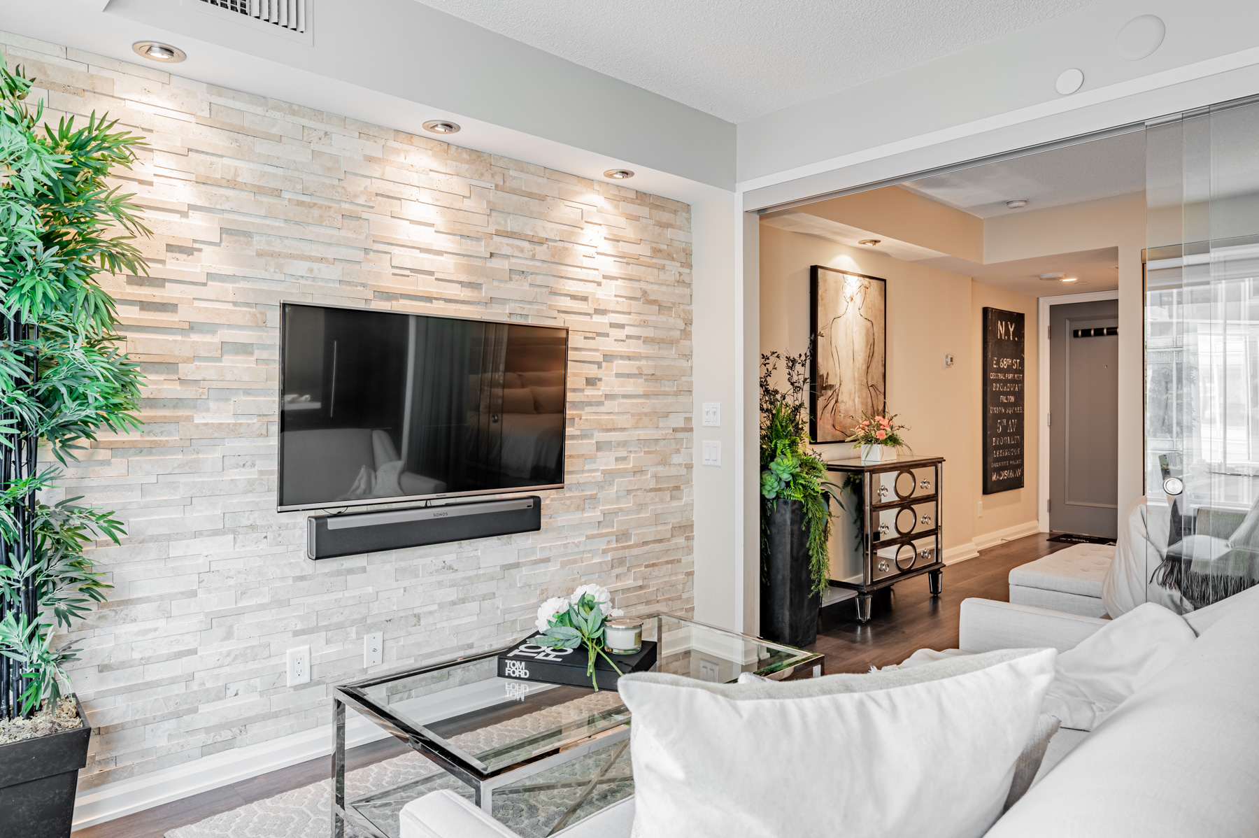 155 Yorkville Ave Unit 712 living room accent wall with mounted TV and Sonos speaker system.