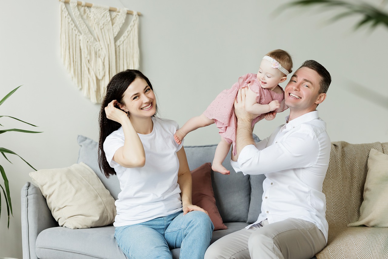 Home with happy young Millennials holding baby.