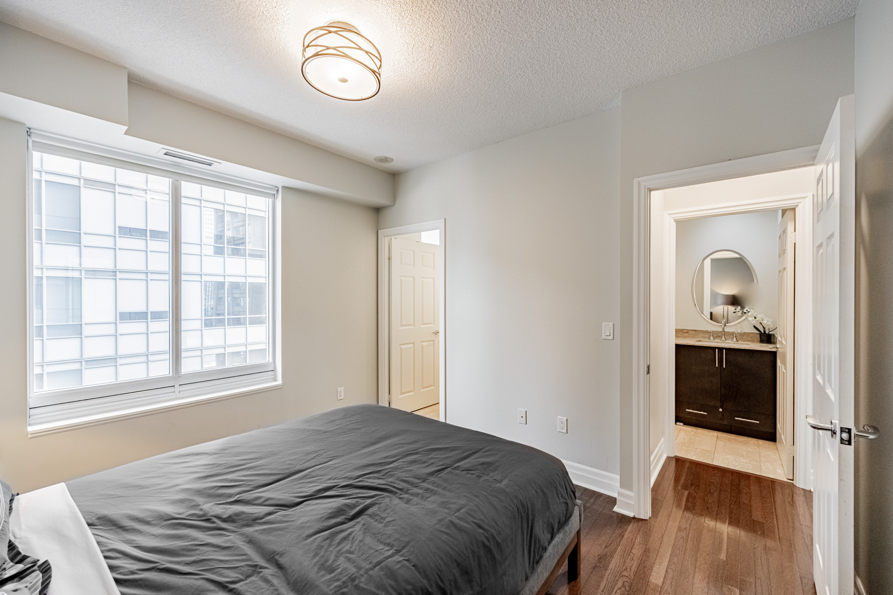 Condo bedroom with large windows.