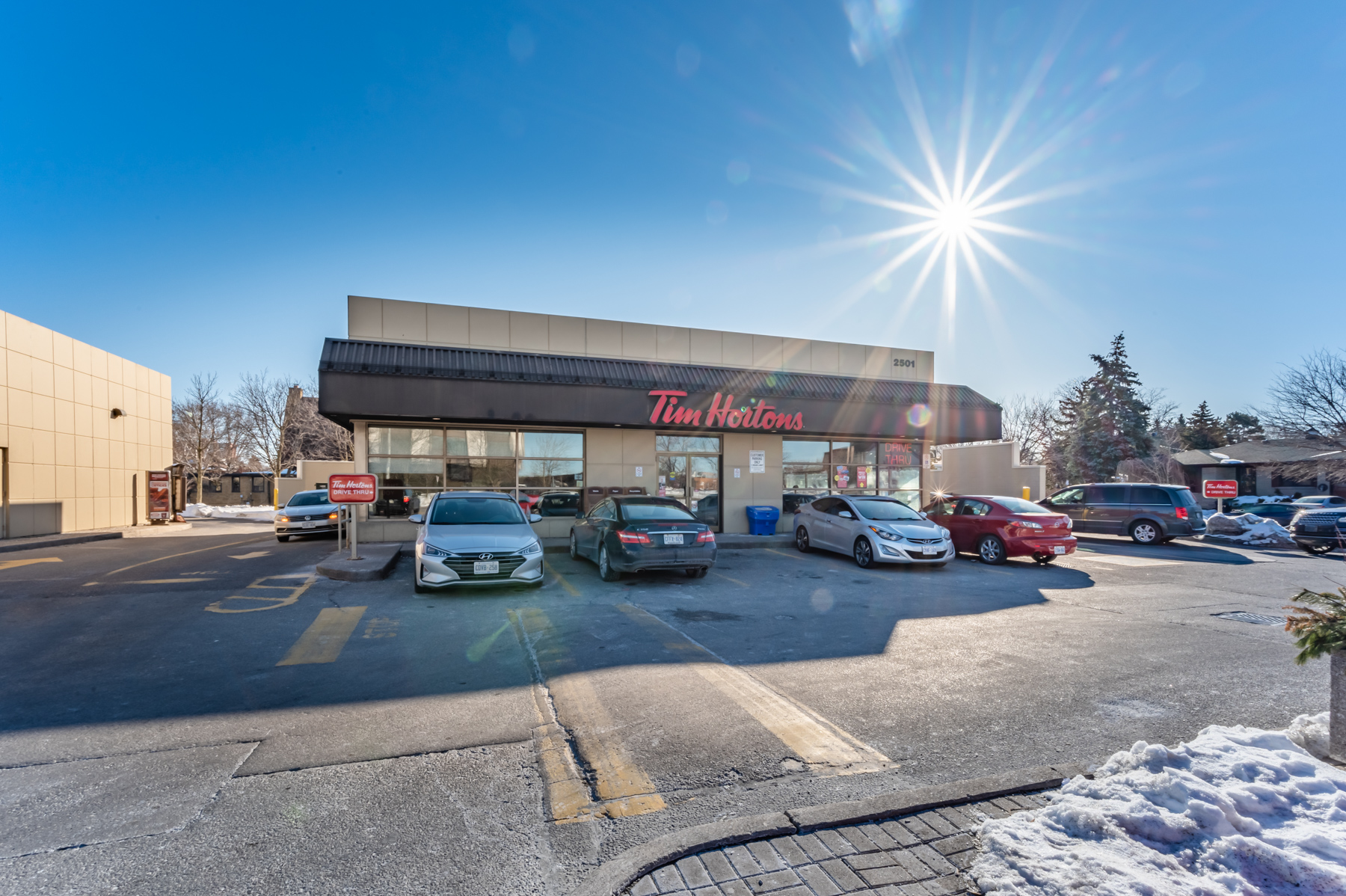 Cars parked in front of Tim Hortons restaurant.