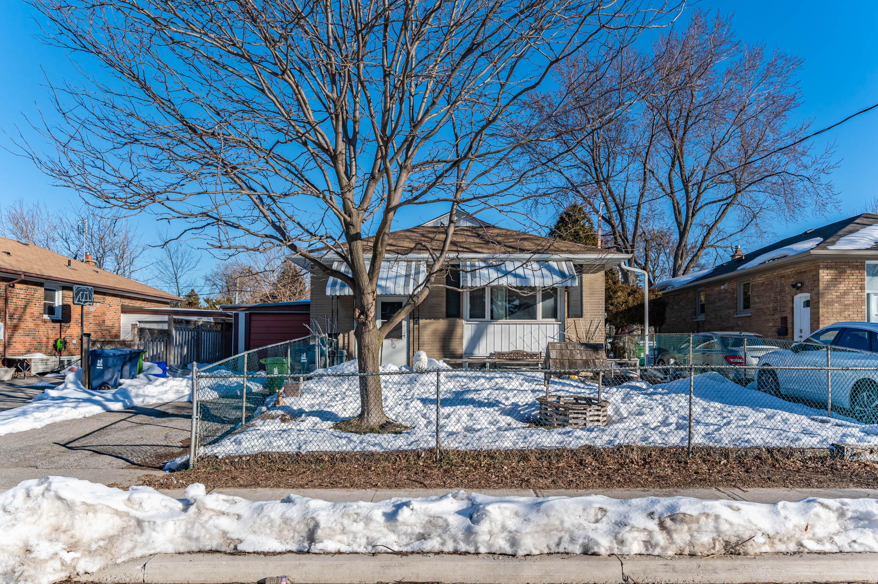 Facade of 6 Wishing Well Dr, detached bungalow with tree in front yard.