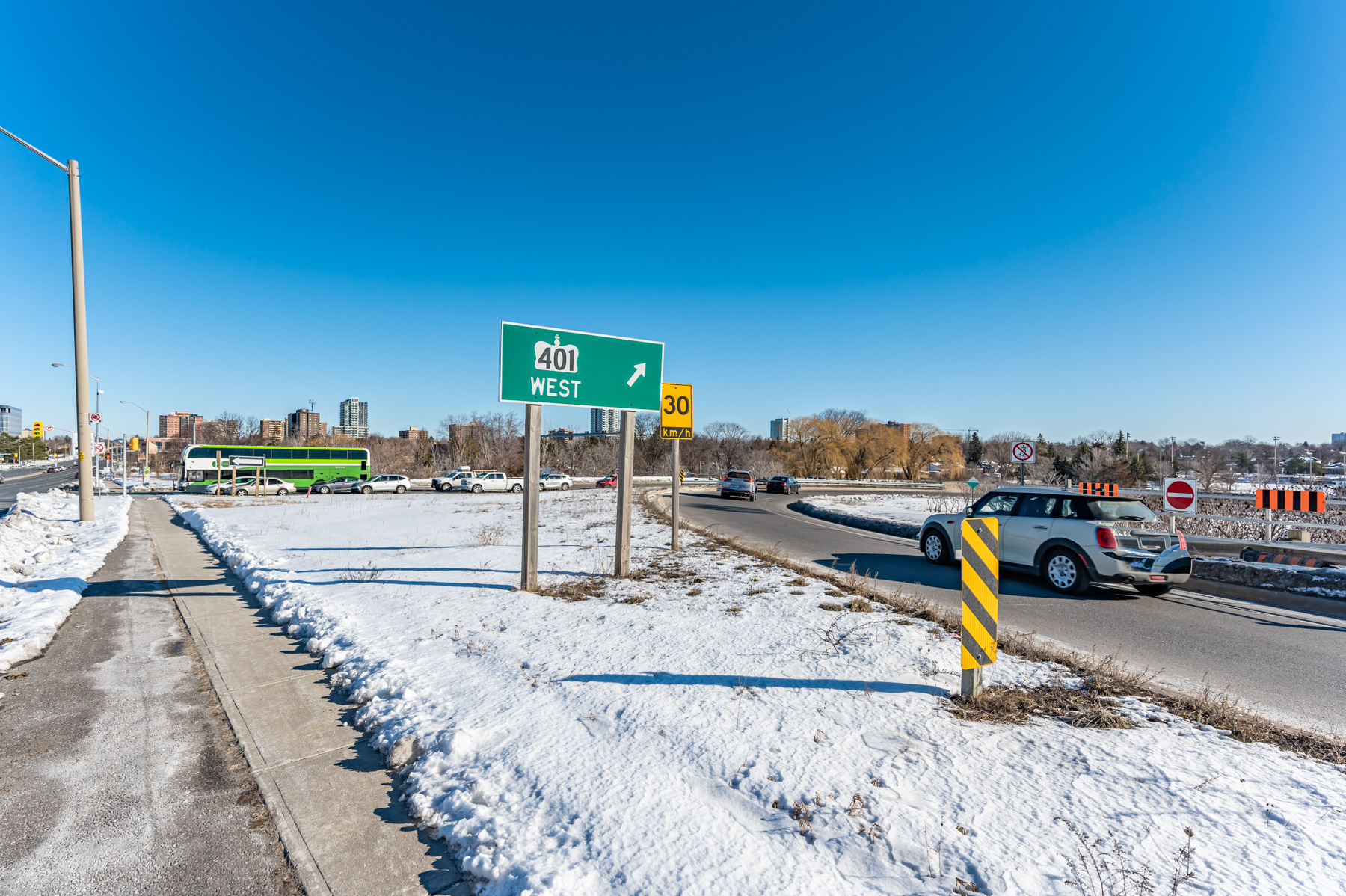 Green Highway 401 sign next to highway on-ramp.