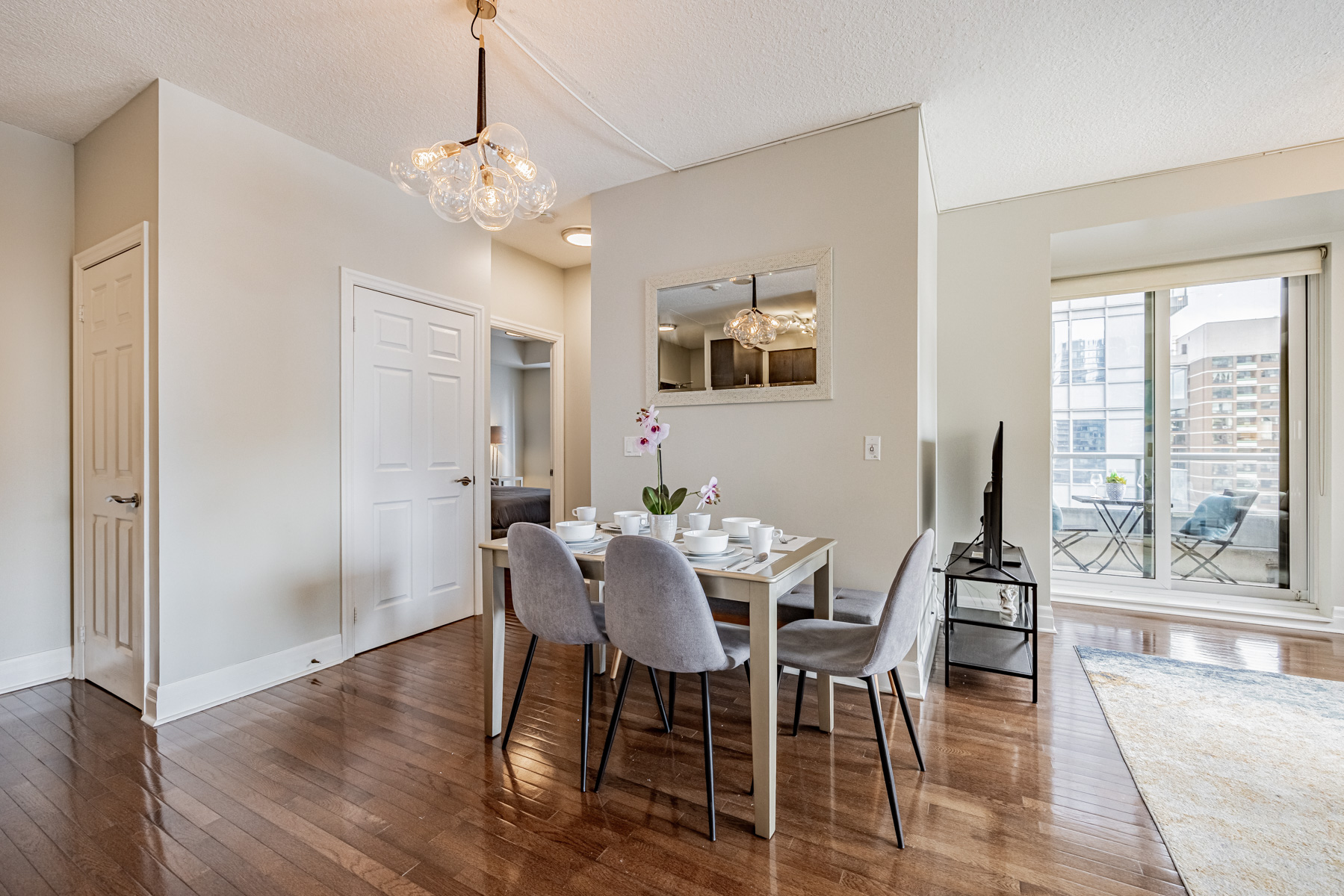 Condo dining room with dark hardwood floors and light gray walls and ceiling.