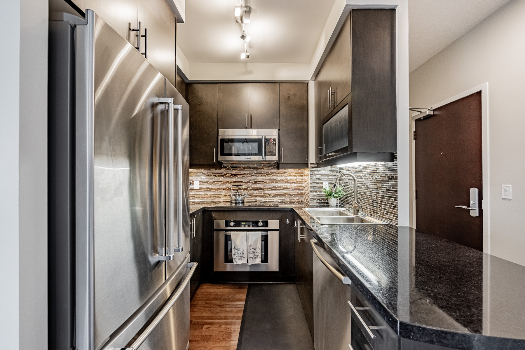 Dark coloured u-shaped kitchen with wall-mounted cabinets – 35 Balmuto St Unit 1209.